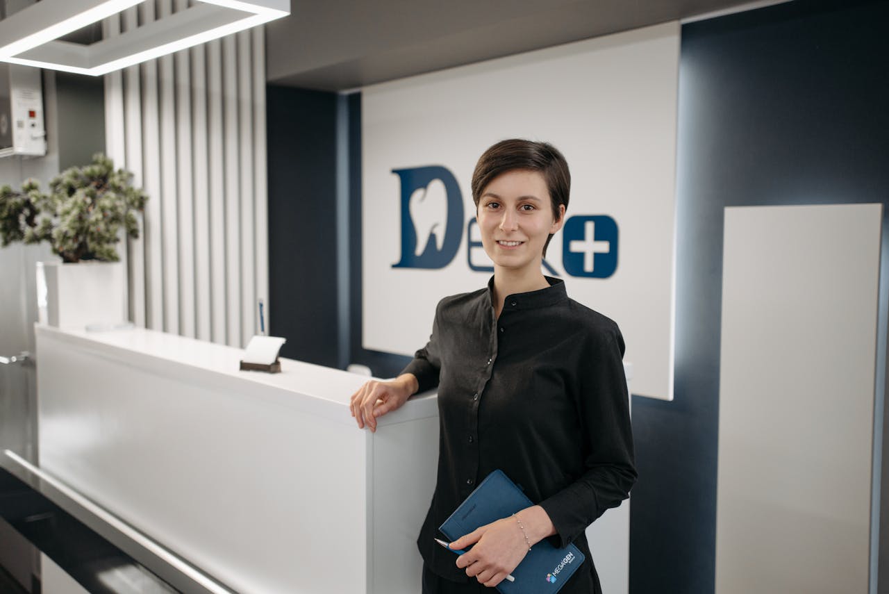 Smiling receptionist in a modern dental clinic lobby.